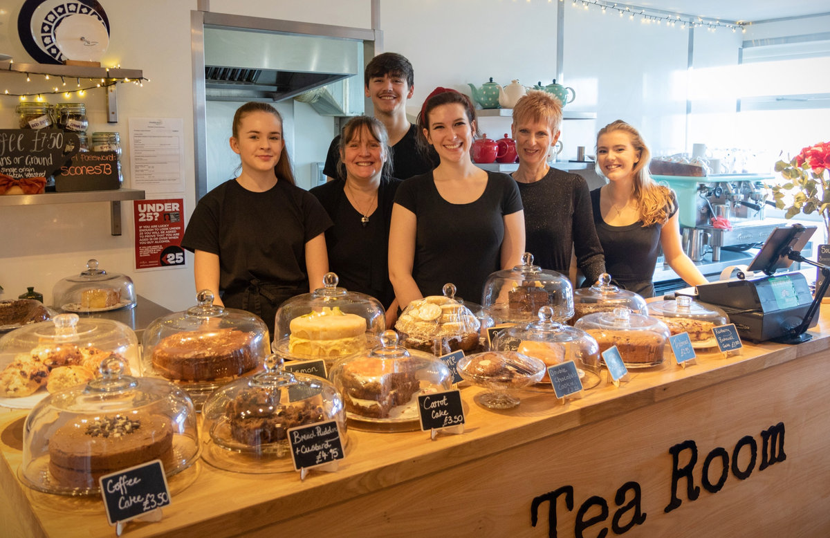 Team of friendly waiting staff at the Tea Room in Knutsford with huge display of home-baked cakes