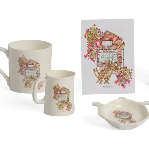 Close-up of Tea Room mugs and a teapot-shaped tea tidy